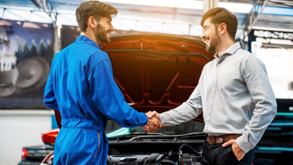 Zwei Männer schütteln sich die Hände nach einem erfolgreichen Gebrauchtwagenkauf